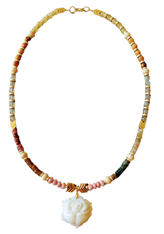 Necklace with multicolored beads and a white flower pendant on a beige background