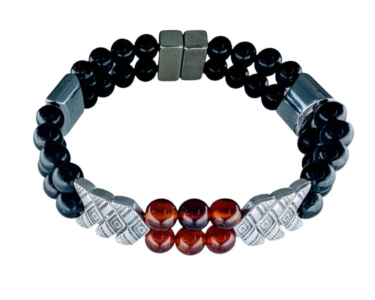 Bracelet with black beads, red stones, and silver accents on a light gray background